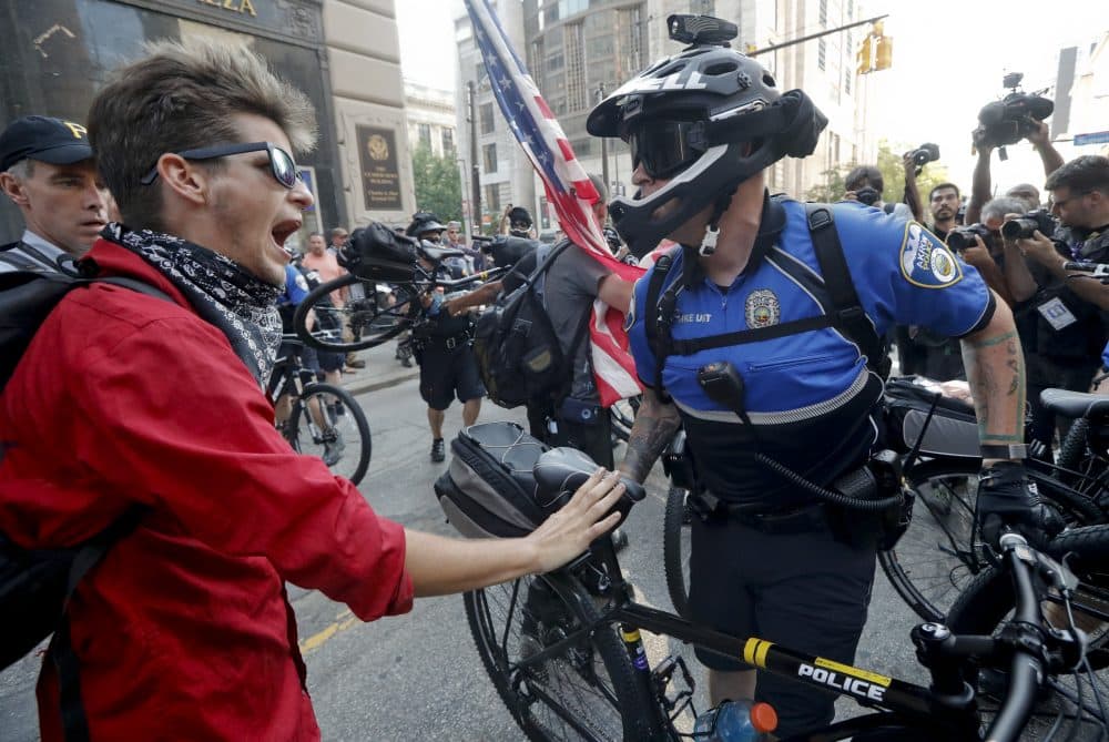 A protester interacts with a police officer during a demonstration Tuesday. (John Minchillo/AP)