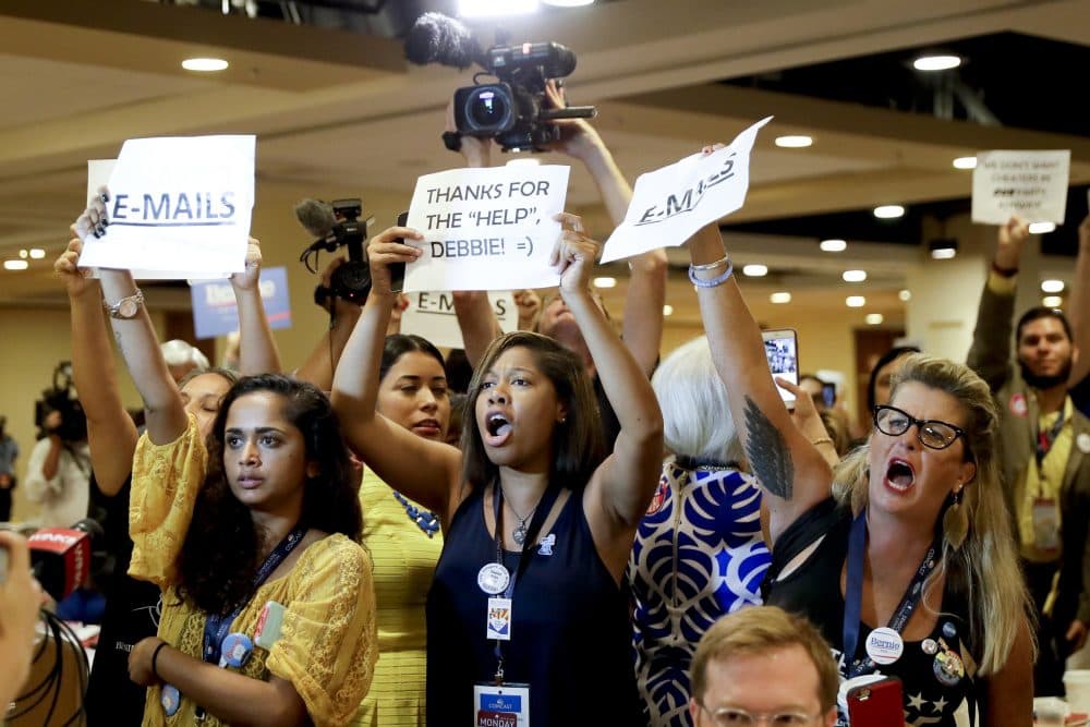 Protesters yell as Debbie Wasserman Schultz arrives for a Florida delegation breakfast. She announced her resignation Sunday amid furor over an email leak that revealed a bias against Bernie Sanders inside the committee. (Matt Slocum/AP)