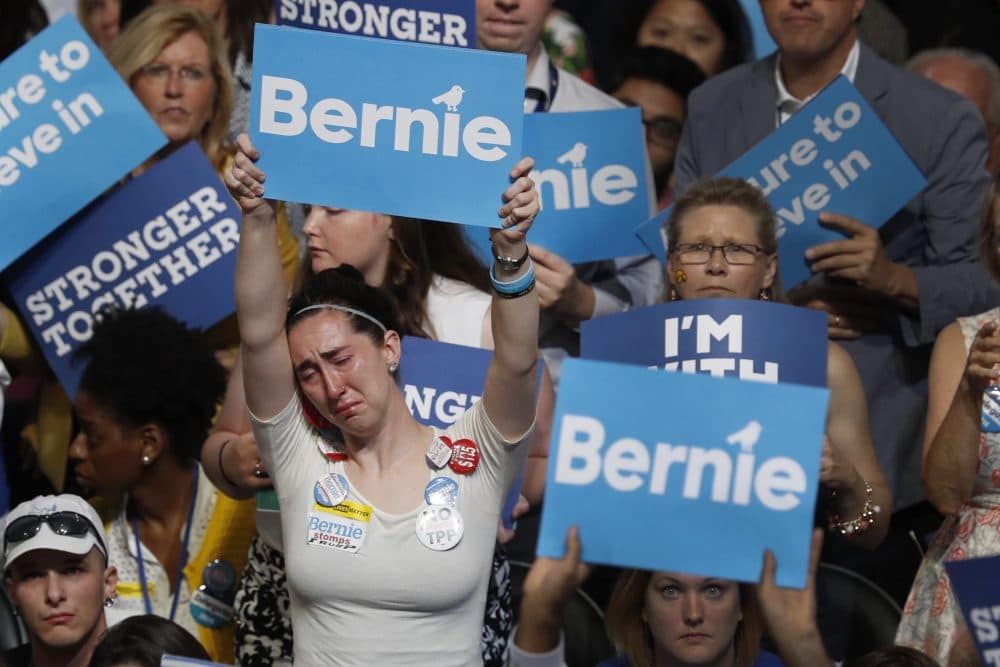 A disappointed Bernie Sanders supporter holds up her sign as Sanders speaks at the DNC Monday night. (Mary Altaffer/AP)