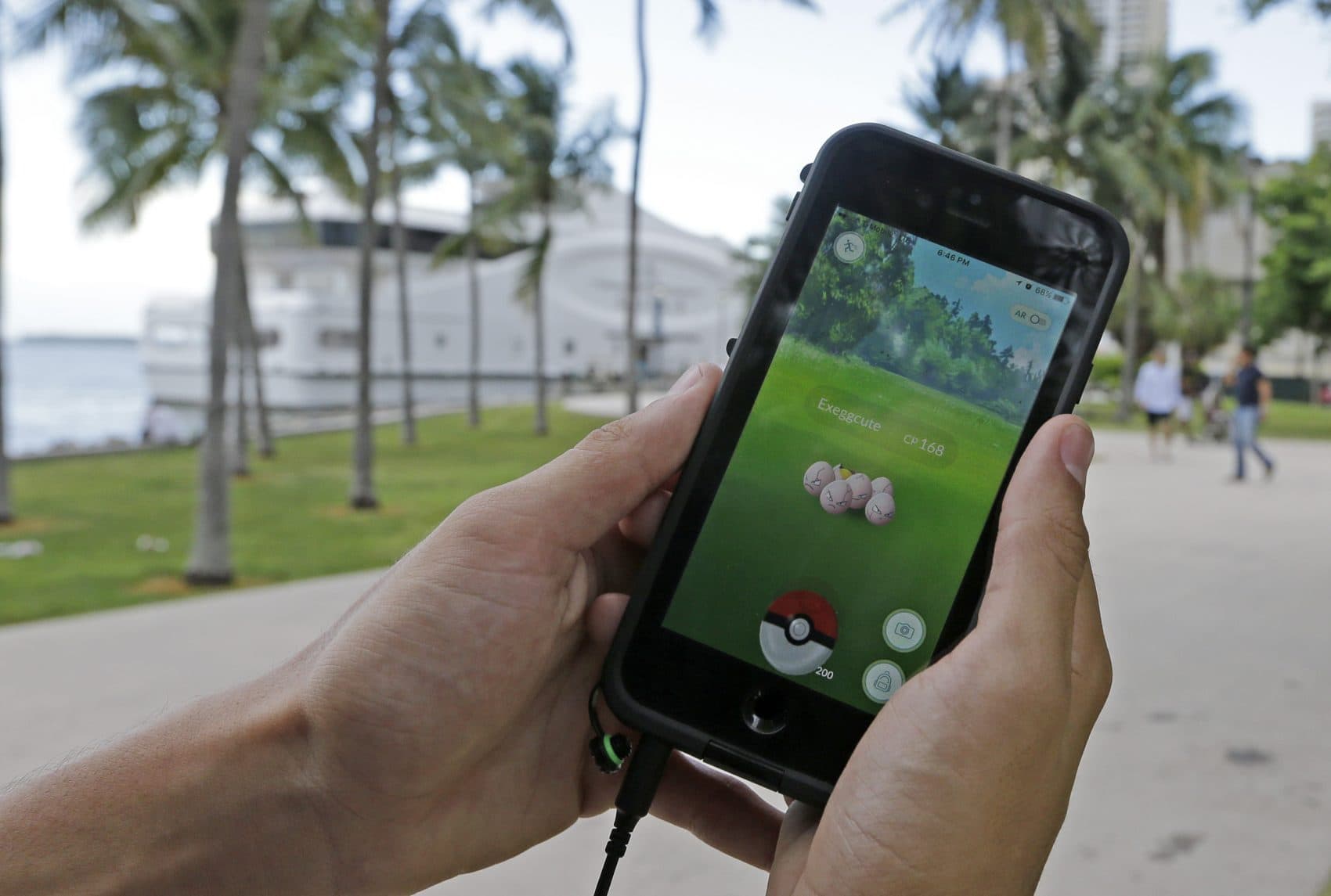 Exeggcute, a Pokemon, is found by a Pokemon Go player, Tuesday, July 12, 2016, at Bayfront Park in downtown Miami. The "Pokemon Go" craze has sent legions of players hiking around cities and battling with "pocket monsters" on their smartphones. It marks a turning point for augmented reality, or technology that superimposes a digital facade on the real world. (Alan Diaz/AP)