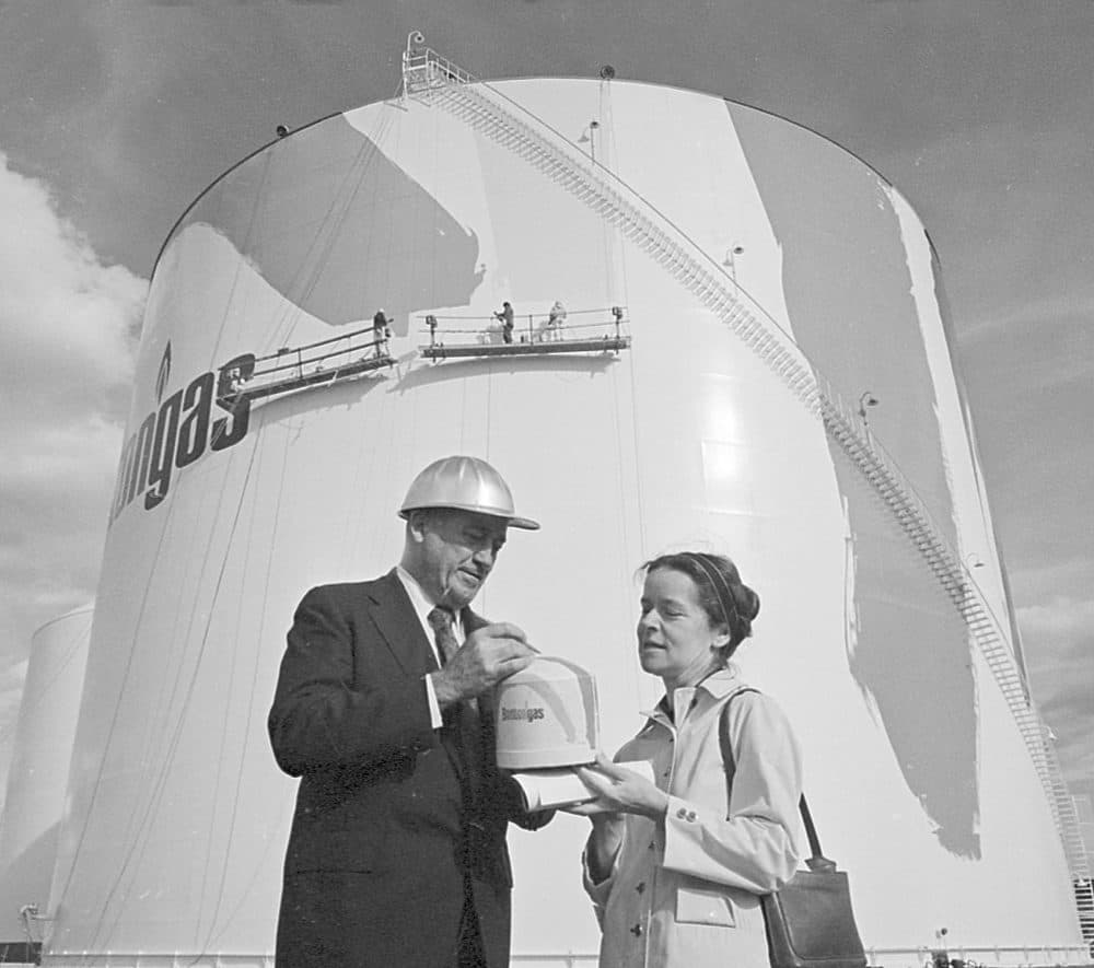 As painters cover 150-foot-high tank with rainbow stripes, artist Corita Kent and Karl Kunberger, manager of gas supply and construction, look at a finished model, on Oct. 19, 1971. (AP)