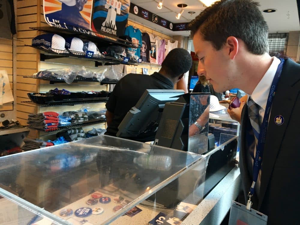 Trevor Doiron, 17 -- one of the youngest delegates at the Democratic National Convention -- checks out swag inside the Wells Fargo Center. (Shannon Dooling/WBUR)