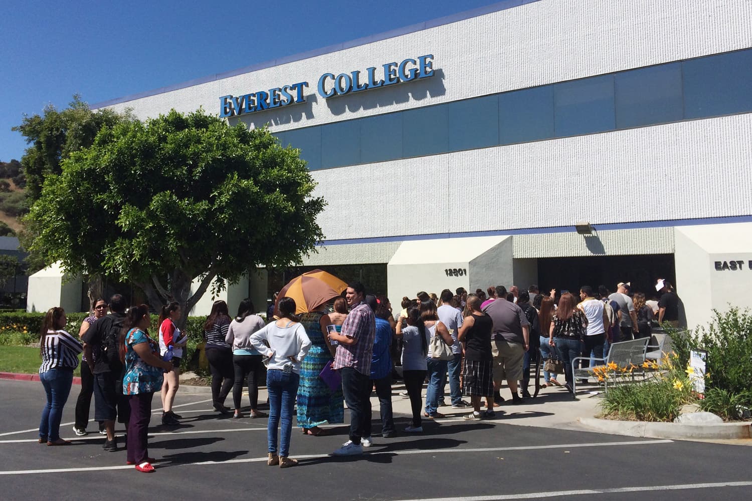 In this April 28, 2015 file photo, students wait outside Everest College in Industry, Calif., hoping to get their transcripts and information on loan forgiveness and transferring credits to other schools. (Christine Armario/AP)