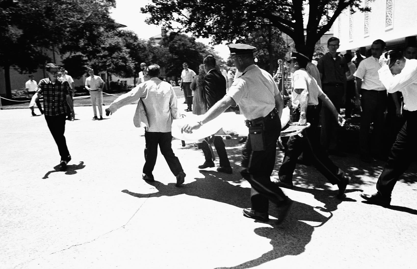In this Aug. 1, 1966 file photo, one of the victims of Charles Joseph Whitman, the sniper who gunned down victims from a perch in the University of Texas tower, is carried across the campus to a waiting ambulance in Austin. (AP)