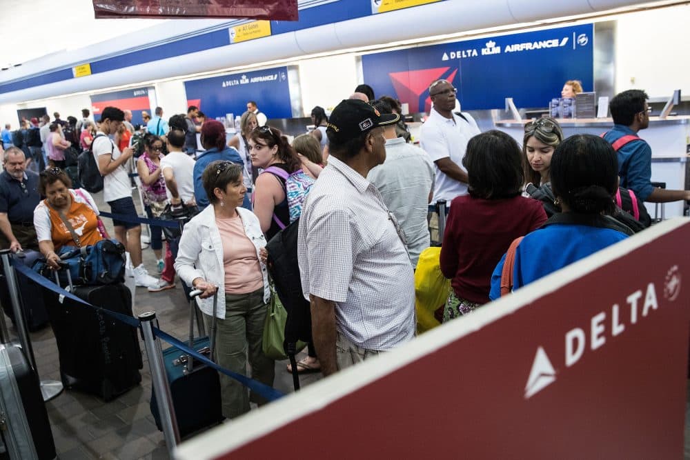 Travelers wait in line at the Delta check-in counter at LaGuardia Airport , Aug. 8, 2016 in the Queens borough of New York City. Delta flights around the globe were grounded and delayed on Monday morning due to a system outage. (Drew Angerer/Getty Images)
