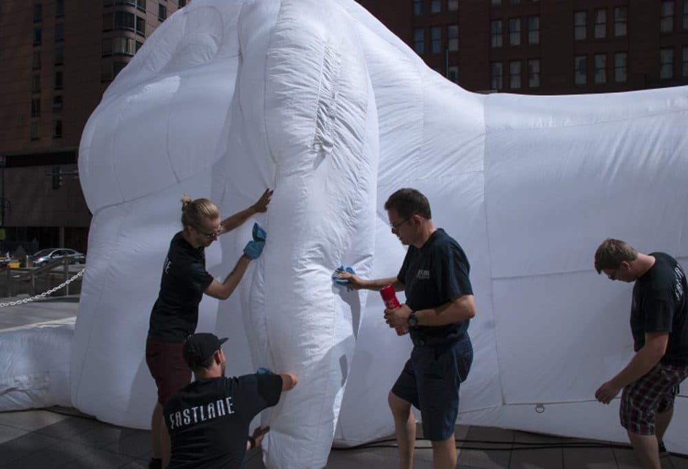 Doug Lane (center) and his Fastlane Productions team clean one of five inflatable rabbit sculptures by Australian artist Amanda Parer that appeared in Denver in June as part of a series called &quot;Intrude&quot; commissioned by Arts Brookfield. (Corey H. Jones/CPR News)