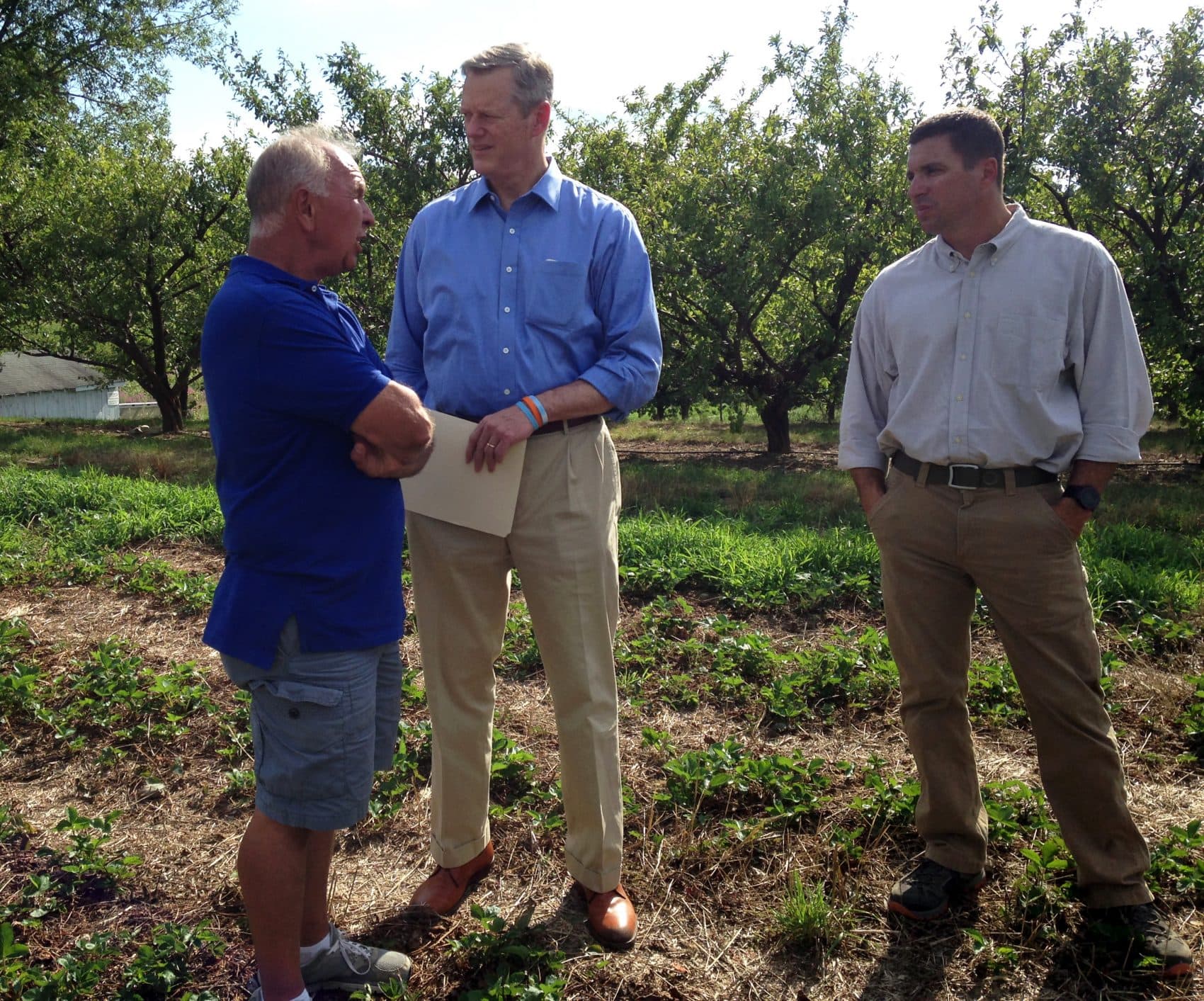 Farmer Michael Smolak, Gov. Charlie Baker and Energy and Environmental Affairs Secretary Matthew Beaton at Smolak's farm in North Andover. (Steve Brown/WBUR)