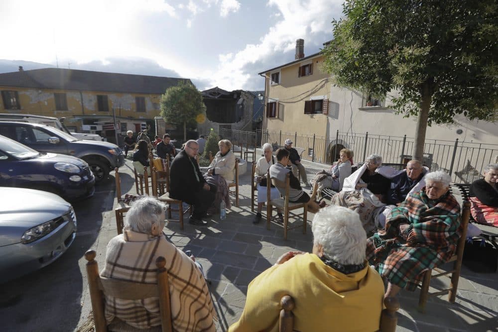 Residents sit outdoor following an earthquake in Cumuli, Italy on Wednesday. (Andrew Medichini/AP)