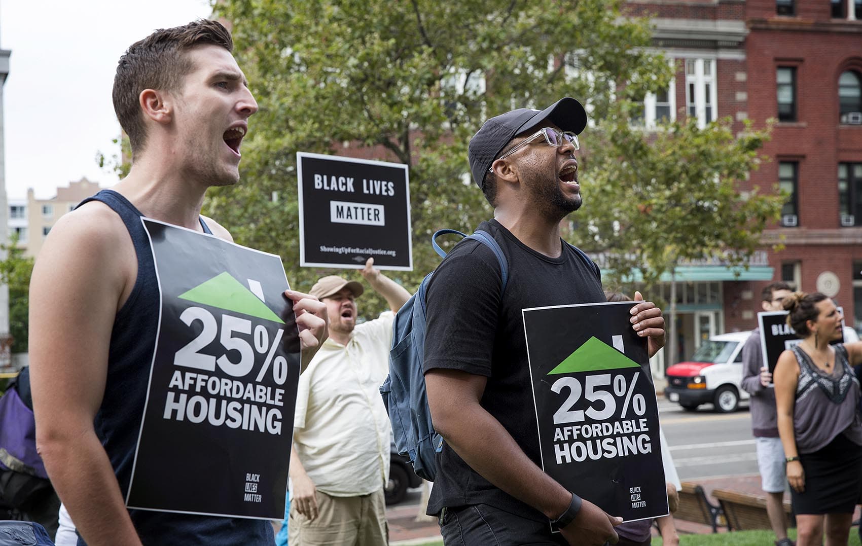 Protesters hold up signs that read "25% affordable housing." (Robin Lubbock/WBUR)