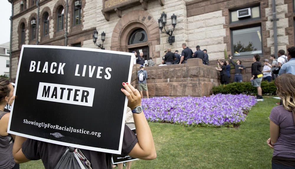 Some demonstrators held Black Lives Matter signs. (Robin Lubbock/WBUR)