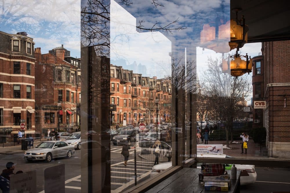 Boston is transforming Newbury Street, one of the city's most popular shopping destinations, into a pedestrian walkway for a day. Here, Newbury Street is seen through a glass window. (Lei Han/Flickr)