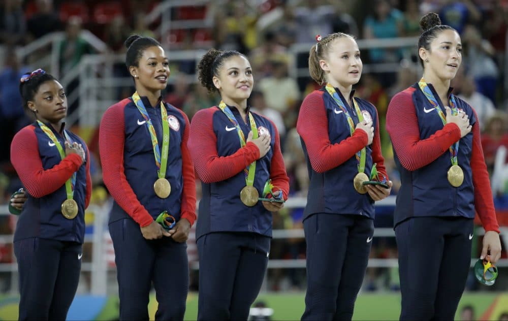 U.S. gymnasts and gold medalists, left to right, Simone Biles, Gabrielle Douglas, Lauren Hernandez, Madison Kocian and Aly Raisman stand for their national anthem during the medal ceremony for the artistic gymnastics women's team at the 2016 Summer Olympics in Rio de Janeiro, Brazil, Tuesday, Aug. 9, 2016. (Julio Cortez/AP) 