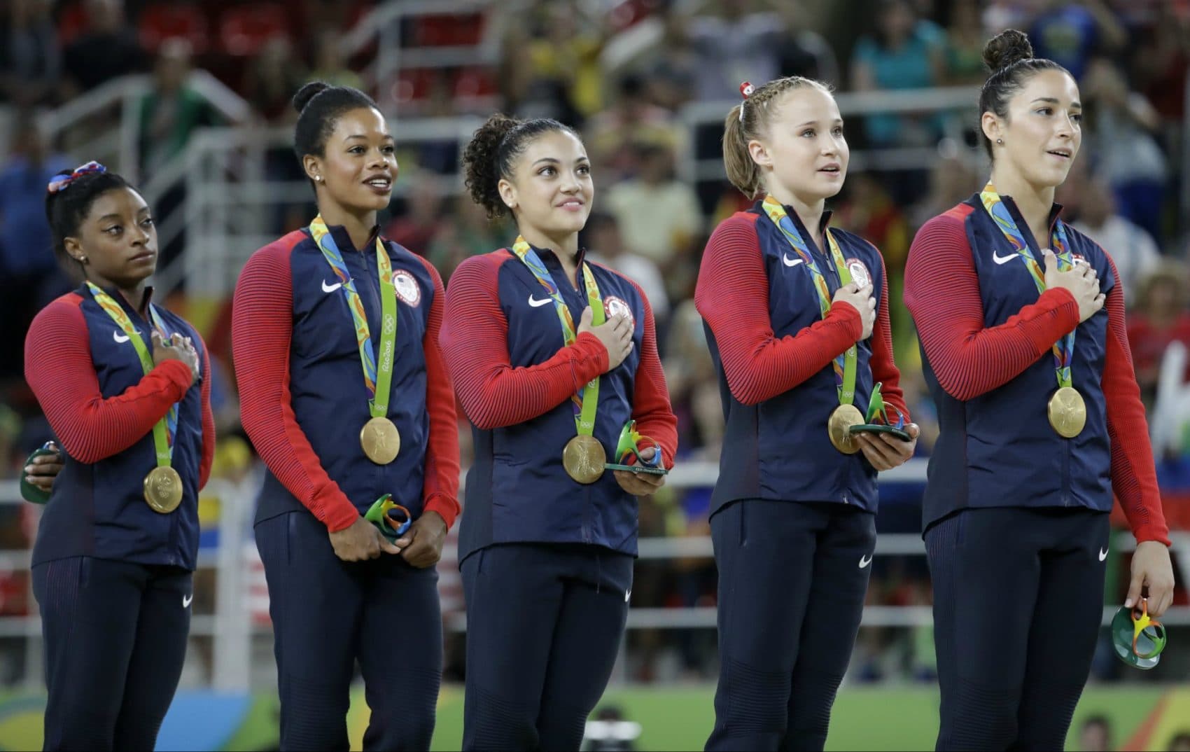 U.S. gymnasts and gold medalists, left to right, Simone Biles, Gabrielle Douglas, Lauren Hernandez, Madison Kocian and Aly Raisman stand for their national anthem during the medal ceremony for the artistic gymnastics women's team at the 2016 Summer Olympics in Rio de Janeiro, Brazil, Tuesday, Aug. 9, 2016. (Julio Cortez/AP) 