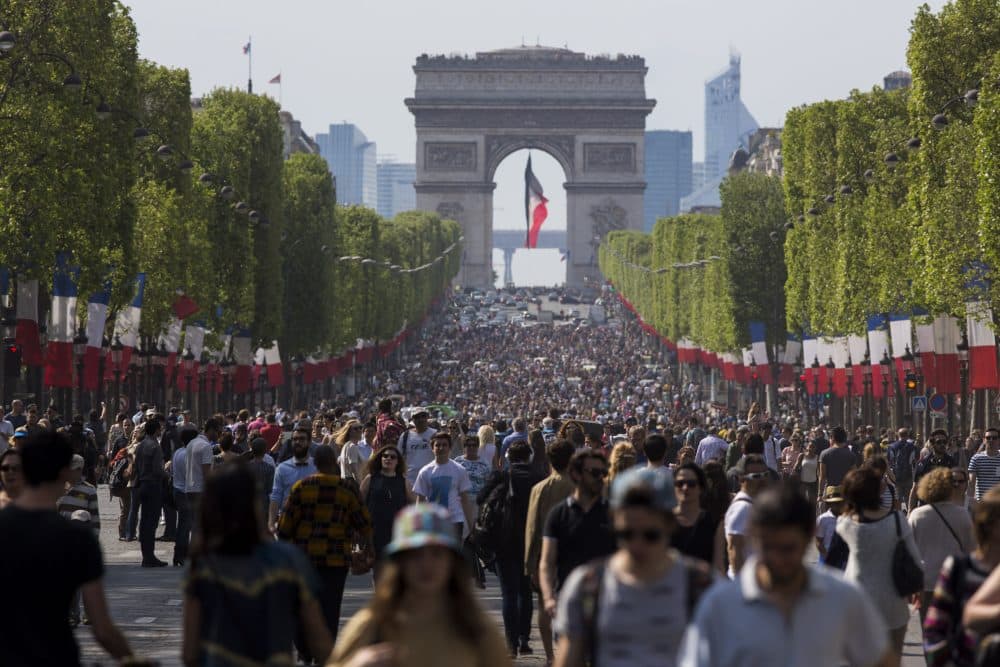 Pedestrians take over the Champs Elysees on Sunday, May 8, as part of a new program to ban traffic from the famous Paris avenue once a month. (Kamil Zihnioglu/AP)