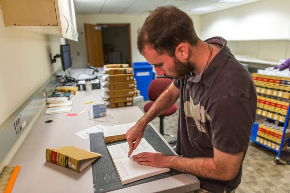 Before being scanned, a case law book must first be cut from its binding. (Brooks Kraft/Harvard Law School)