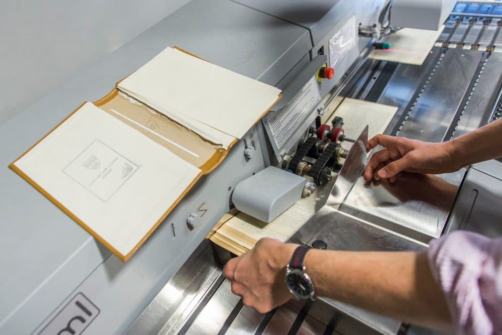 One of Harvard's case law books goes through the high speed scanner. (Brooks Kraft/Harvard Law School)