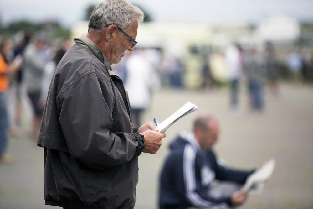 George Wolfe looks at the racing program on July 9 at Suffolk Downs. (Courtesy of Lauren Owens/The Eye)