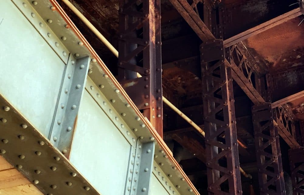 A view of the old, rusted spandrel columns rising from the main arches to support the road deck on the bridge's downstream side. (Wade Roush for WBUR)