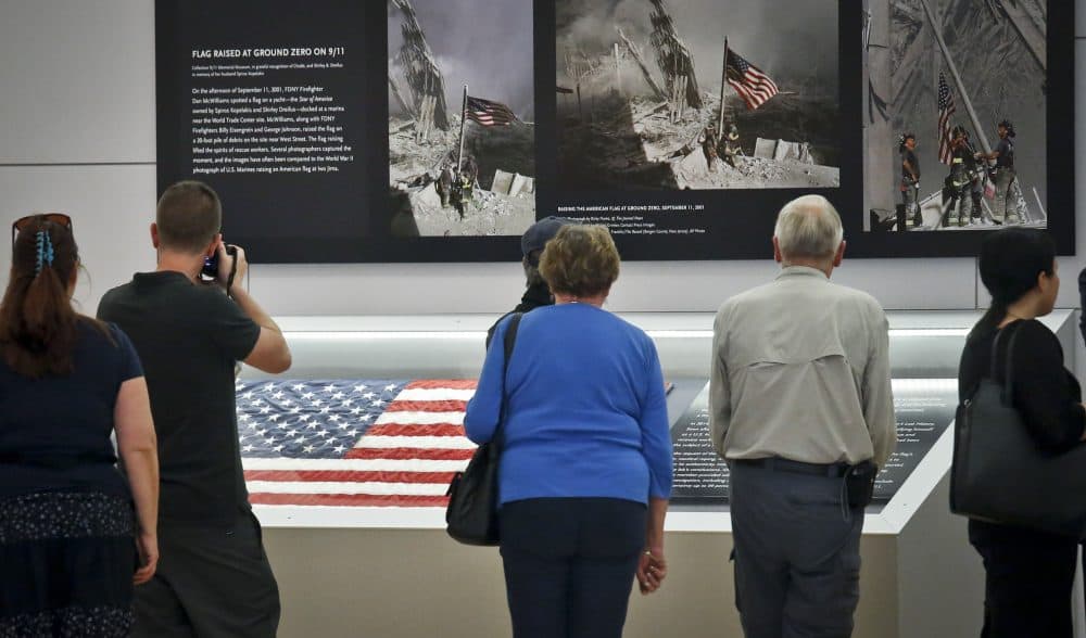Visitors view the display for the American flag that firefighters hoisted at Ground Zero in the hours after the 9/11 terror attacks at the Sept. 11 museum in New York. (Bebeto Matthews/AP)