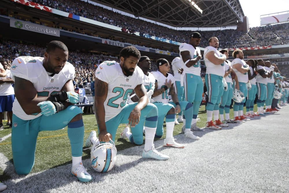From left, Miami Dolphins' Jelani Jenkins, Arian Foster, Michael Thomas, and Kenny Stills, kneel during the singing of the national anthem before an NFL football game against the Seattle Seahawks, Sunday, Sept. 11, 2016, in Seattle. (Stephen Brashear/AP)
