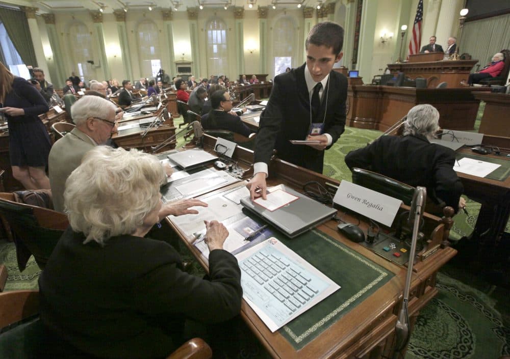 Electoral College member Christopher Tumbeiro, right, passes a ballot to Gwen Regalia, before the votes were taken for president and vice president, at the Capitol in Sacramento, Calif., Monday, Dec. 17, 2012. (Rich Pedroncelli/AP)