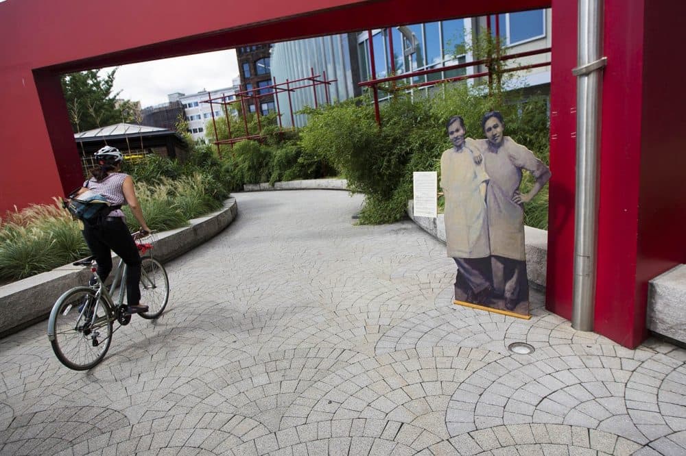 &quot;Two Shopkeepers&quot; stand at the edge of Chinatown Park. (Jesse Costa/WBUR)