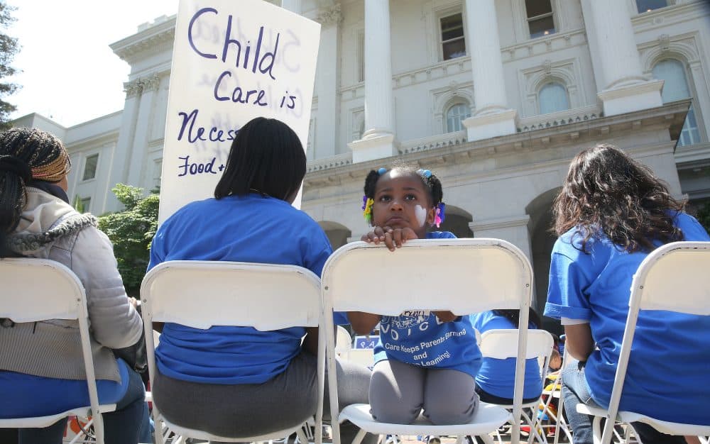 In this May 6, 2015 photo, a young girl sits with her mother at a rally calling for increased child care subsidies at the Capitol in Sacramento, Calif. (Rich Pedroncelli/AP) 