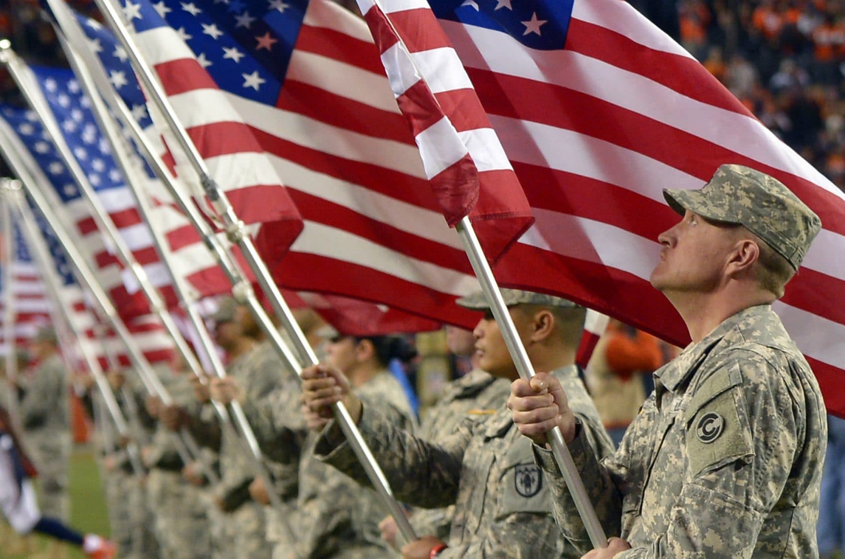 Troops hold American Flags during an NFL football game between the Denver Broncos and the Kansas City Chiefs. (Jack Dempsey/AP)