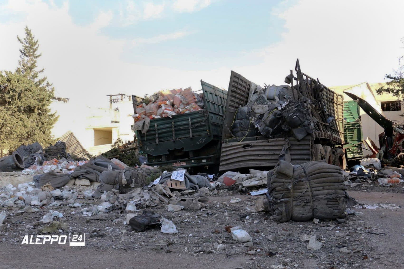 This image provided by the Syrian anti-government group Aleppo 24 news, shows damaged trucks carrying aid, in Aleppo, Syria. A U.N. humanitarian aid convoy in Syria was hit by airstrikes Monday as the Syrian military declared that a U.S.-Russian brokered cease-fire had failed, and U.N. officials reported many dead and seriously wounded. (Aleppo 24 news via AP)