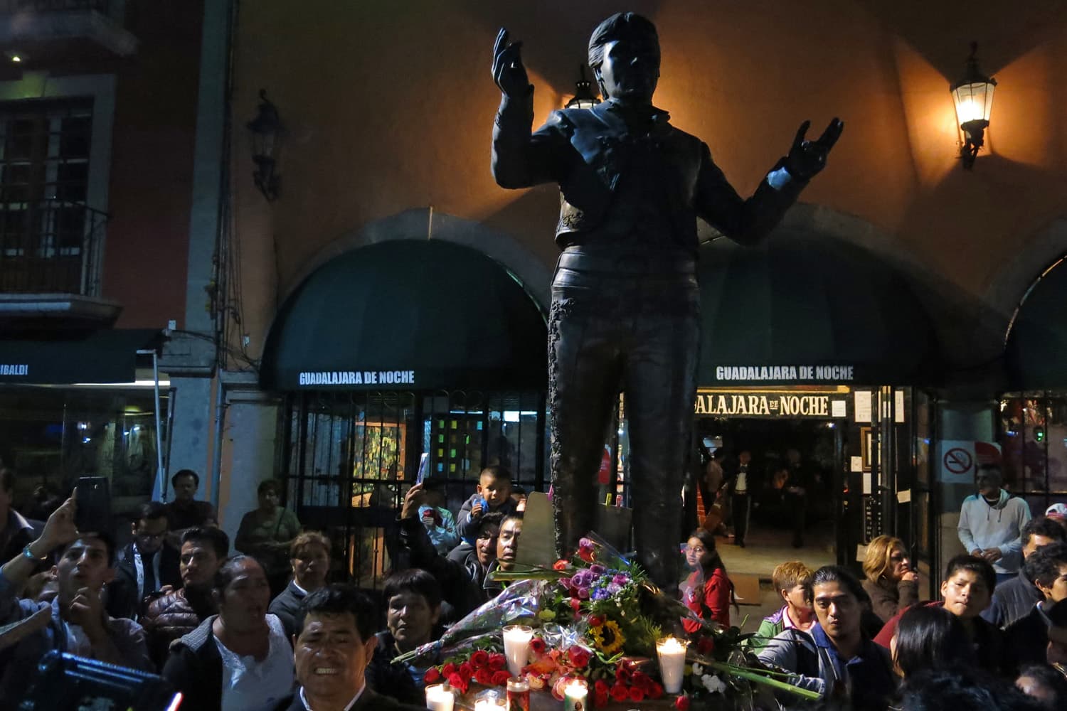 People gather around a statue depicting Mexican superstar songwriter and singer Juan Gabriel in Mexico City's Garibaldi plaza, Sunday Aug. 28, 2016. (Berenice Bautista/AP)