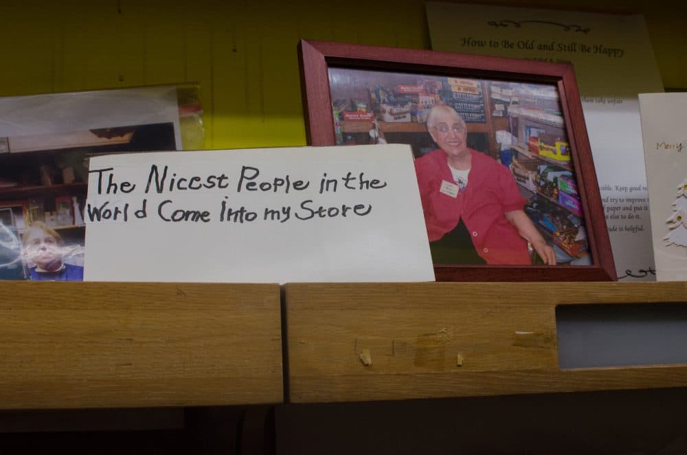 Alongside a framed photo of Irving's owner, Ethel Weiss, a sign Weiss had posted for years on the front door of the shop. (Sharon Brody/WBUR)