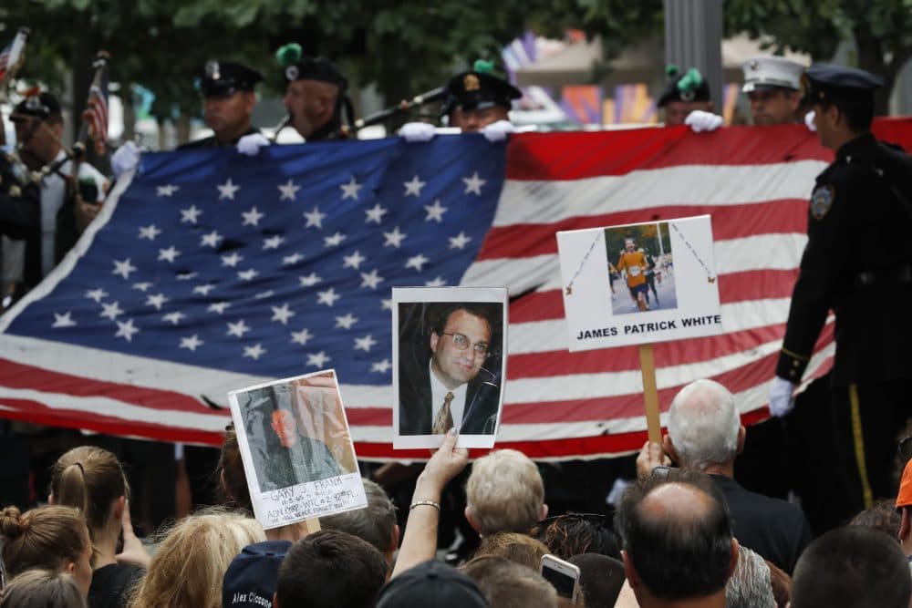 Mourners hold photos of their loved ones during the 15th anniversary of the attacks of the World Trade Center at the National September 11 Memorial on Sunday. (Mary Altaffer/AP)