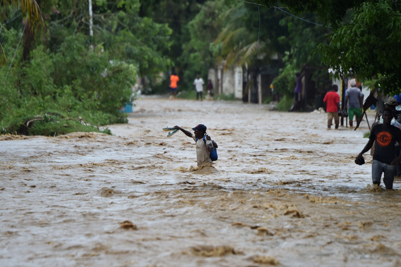 People try to cross the overflowing La Rouyonne river in the commune of Leogane, south of Port-au-Prince, in Haiti on Oct. 5, 2016. (Hector Retamal/AFP/Getty Images)