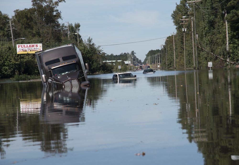A tractor trailer truck is submerged in floodwaters caused by rain from Hurricane Matthew on Highway NC 211 near the Mayfair neighborhood in Lumberton, N.C., Tuesday, Oct. 11, 2016. Lumberton is about two hours south of Enfield, North Carolina. (Mike Spencer/AP)