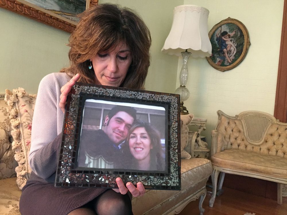 Debbie Deagle holds a photo of her son Stephen and herself. (Martha Bebinger/WBUR)