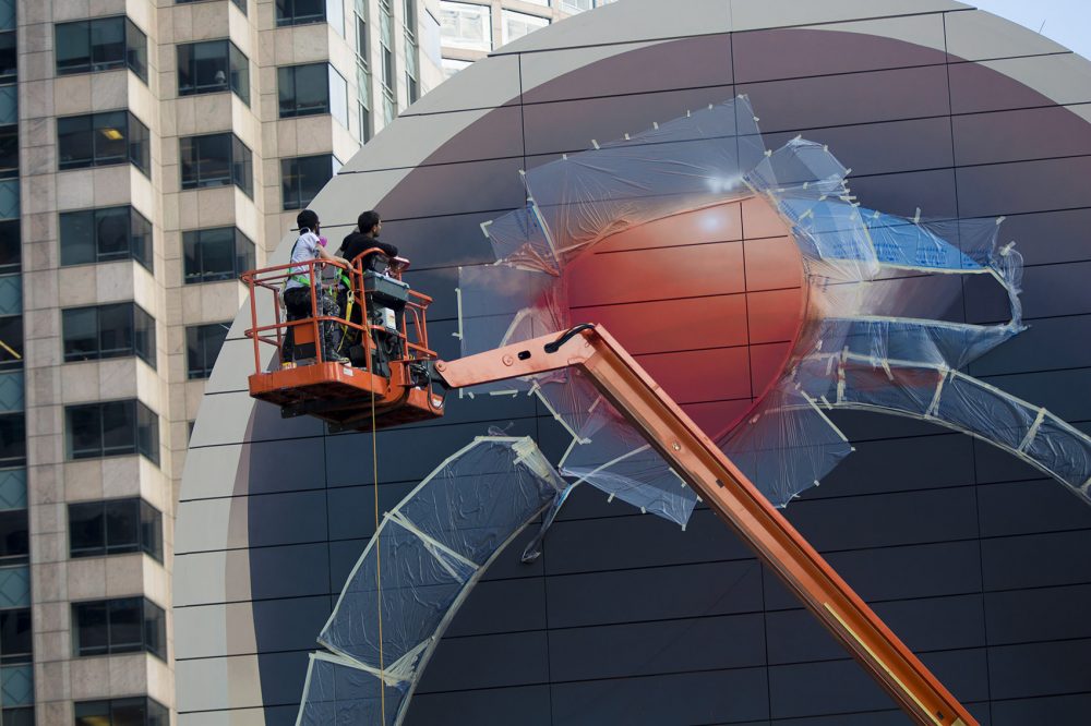 Mehdi Ghadyanloo and his assistant Henry Kunkel examine the balloon at the top of the mural. (Jesse Costa/WBUR)