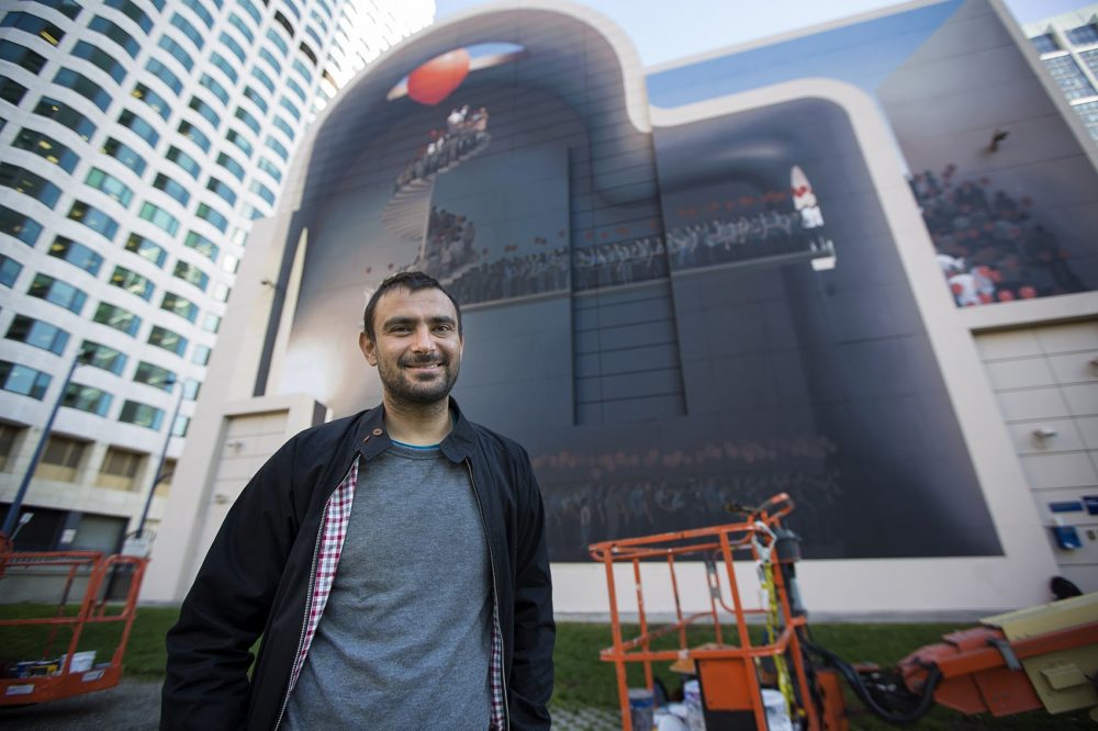 Ghadyanloo stands in front of his completed mural in Dewey Square on Tuesday, Nov. 1, 2016. (Jesse Costa/WBUR)
