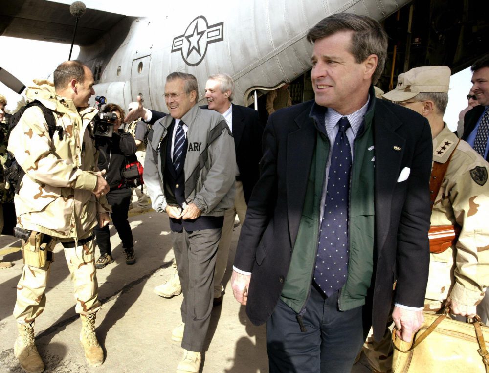 U.S. Defense Secretary Donald Rumsfeld, center, is received off a C-130 transport plane by Paul Bremer, right, the chief of the U.S.-led coalition authority in Iraq, on Feb. 23, 2004 at the Baghdad International Airport. (Jason Reed/AFP/Getty Images)