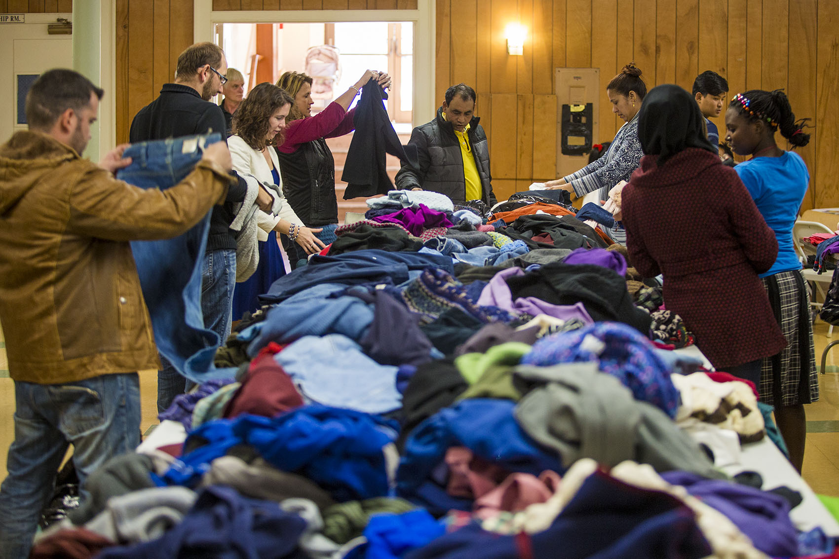 Refugees pick out items at a clothing drive at First United Baptist Church in Lowell. (Jesse Costa/WBUR)