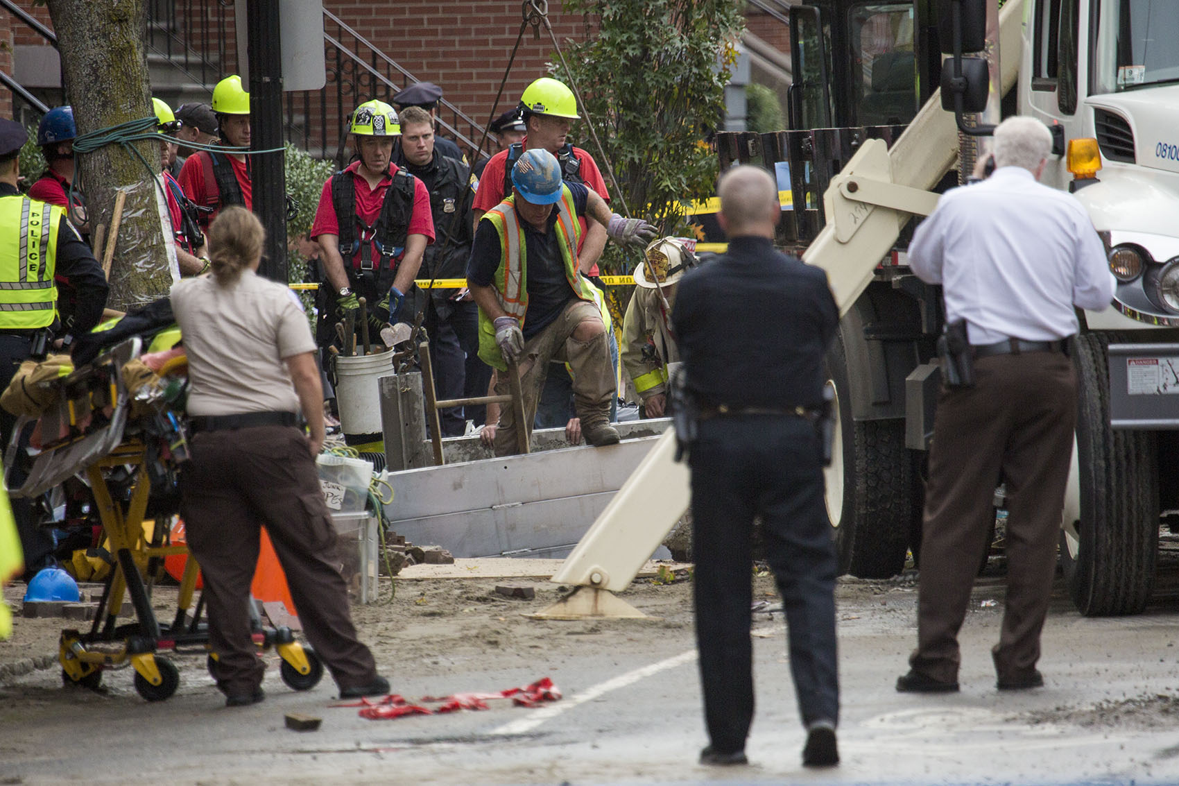 A response team works to recover the bodies of two men who were trapped in a trench during a water main break on Dartmouth Street in Boston's South End. (Jesse Costa/WBUR)