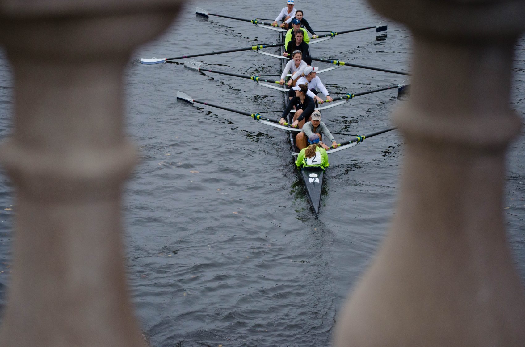 Boats pass under the Weeks Footbridge on their way to the starting line for the Head of the Charles. (Elizabeth Gillis/WBUR)