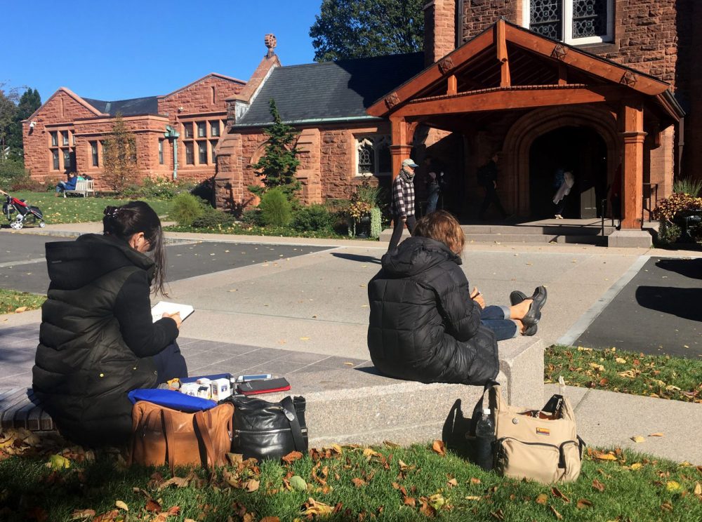 Laura Sfiat, left, and Mia Thurrow, right, of Urban Sketches Boston, draw a building near the entrance of Mount Auburn Cemetery in Cambridge. (Lisa Creamer/WBUR)