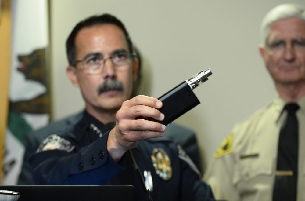 El Cajon Police Department Capt. Jeffery Davis holds up a vape device similar to the one that they claim that Alfred Olango was holding when he was shot. (Denis Poroy/AP)