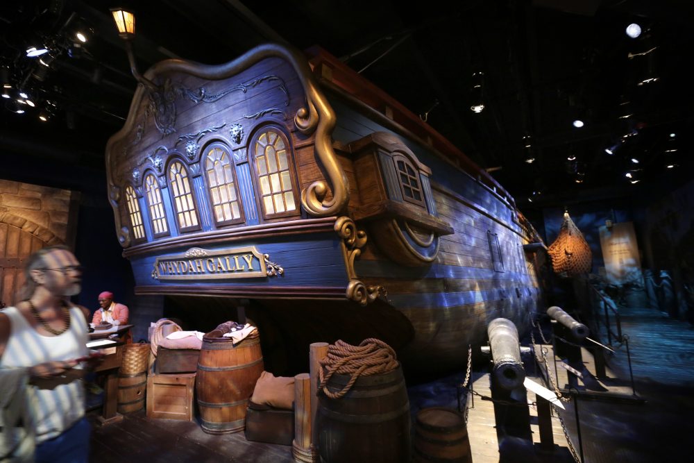 A museum visitor walks past a life-size replica of the hull of the pirate ship Whydah Gally, behind, at the Whydah Pirate Museum, in Yarmouth. (Steven Senne/AP)