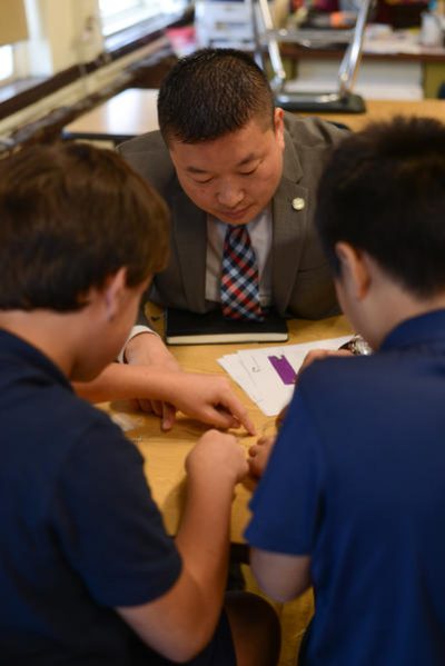 Tommy Chang, Boston superintendent of schools, watches as two students work on their &quot;interactive friendly monster&quot; during Boston STEM Week. (Courtesy City of Boston, Mayor's Office)