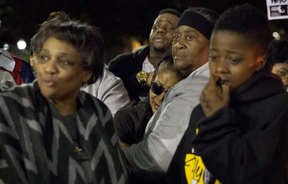 Hope Coleman, wearing sunglasses, is supported by family members at Wednesday evening's vigil and march for her son Terrence Coleman. (Robin Lubbock/WBUR)