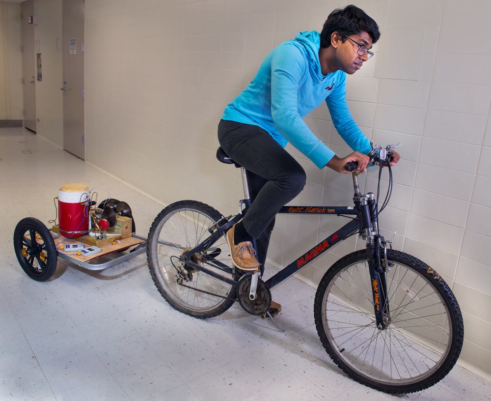 Anurudh Ganesan tests his invention, the VAXXWAGON, to see if it can be pulled by a bicycle. (Courtesy Anurudh Ganesan)
