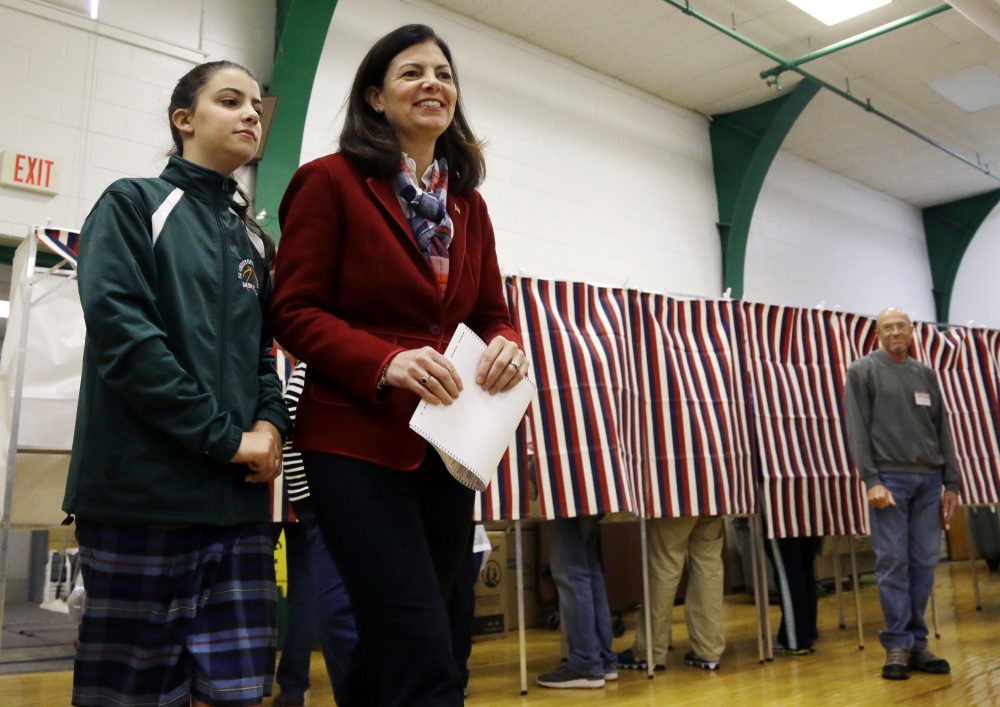 Sen. Kelly Ayotte, R-N.H., accompanied by her daughter, Kate, holds her ballot after leaving the voting booth on Tuesday at Charlotte Avenue Elementary School in Nashua, N.H. (Elise Amendola/AP)