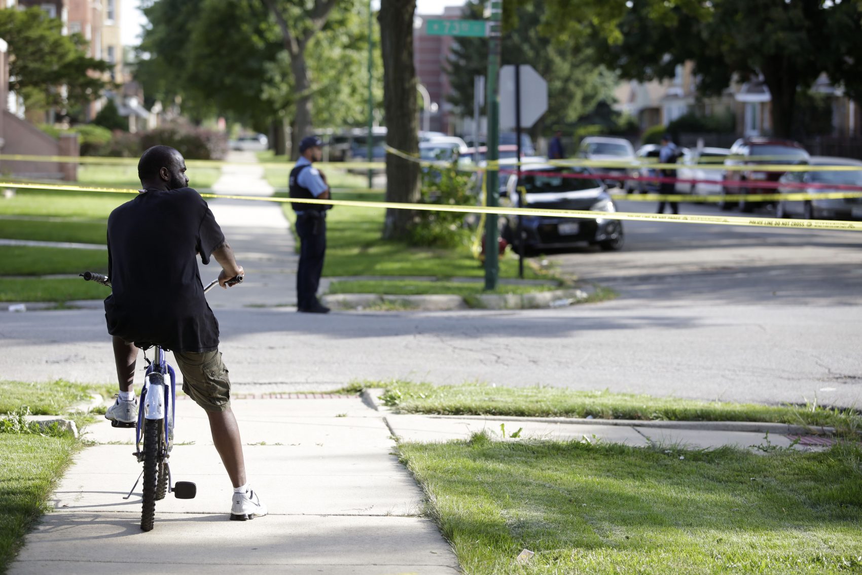 A man on his bike looks at a crime scene where a man was fatally shot on Aug. 31, 2016 in Chicago. (Joshua Lott/Getty Images)