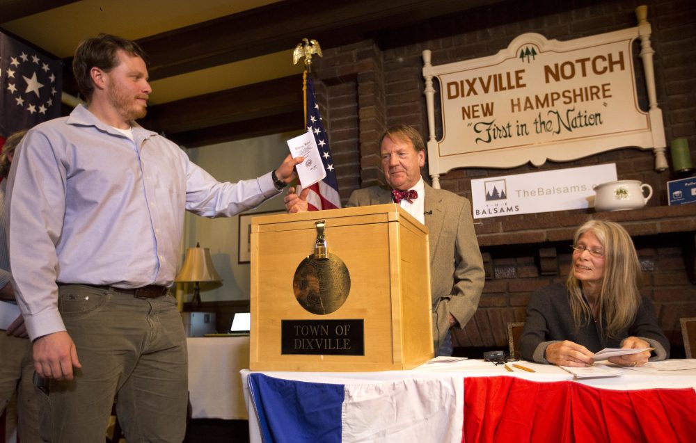 In New Hampshire, Dixville Notch is one of only towns to vote at midnight. Its first voter, Clay Smith, drops his ballot as moderator Tom Tillotson watches Tuesday. Hillary Clinton beat Donald Trump, 4-2 there. (Jim Cole/AP)